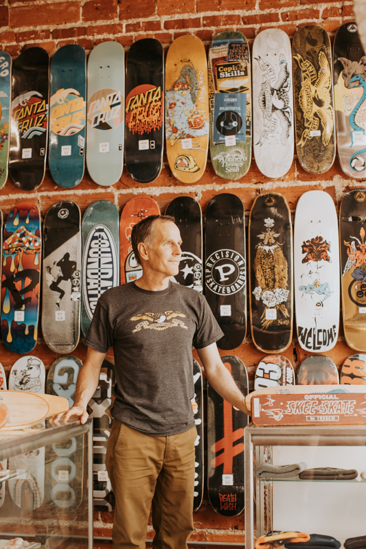 Man in-front of skateboards.
