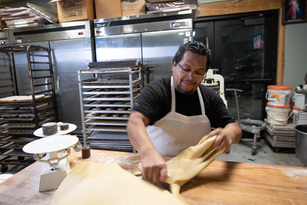 baker cutting dough to knead