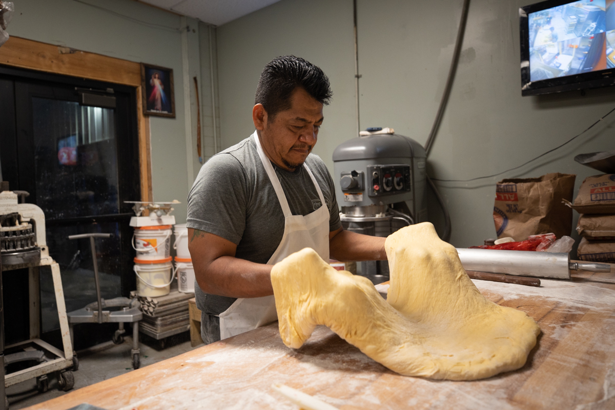 baker lifting dough off table